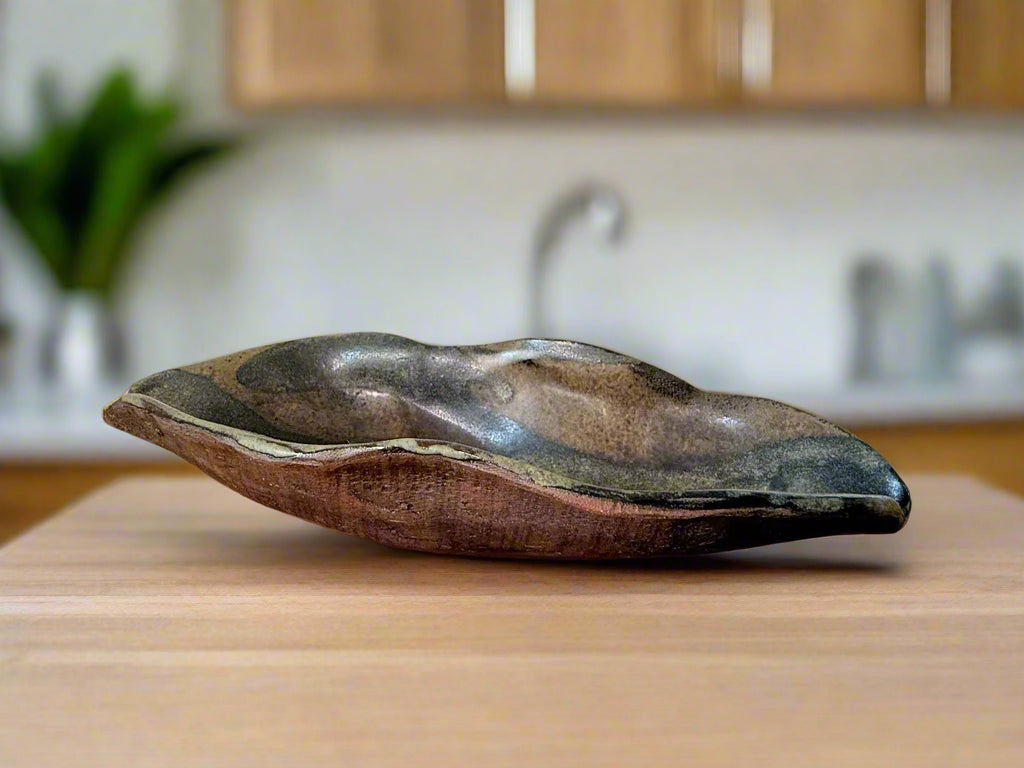Decorative ceramic dish on a wooden surface with a neutral background