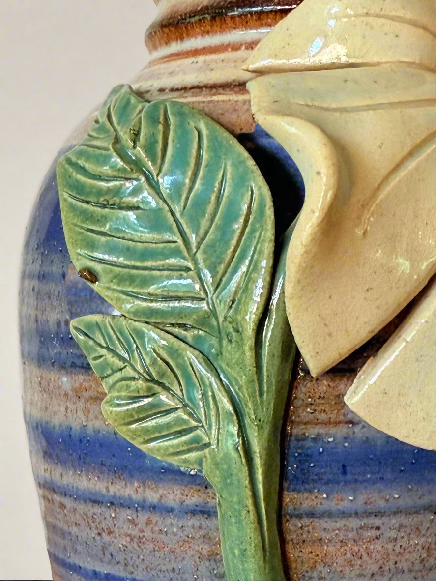 Close-up of a ceramic vase with leaf design and textured surface